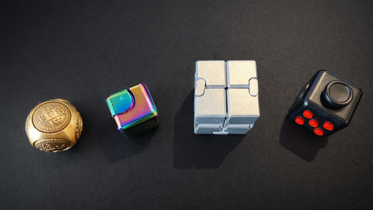 mes 4 cubes anti stress différents sur fond noir fidgets et puzzles