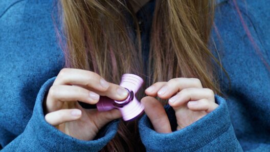 Fidget toy 2026 : jeune fille utilisant un fidget spinner rose en aluminium