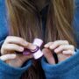 Fidget toy 2026 : jeune fille utilisant un fidget spinner rose en aluminium