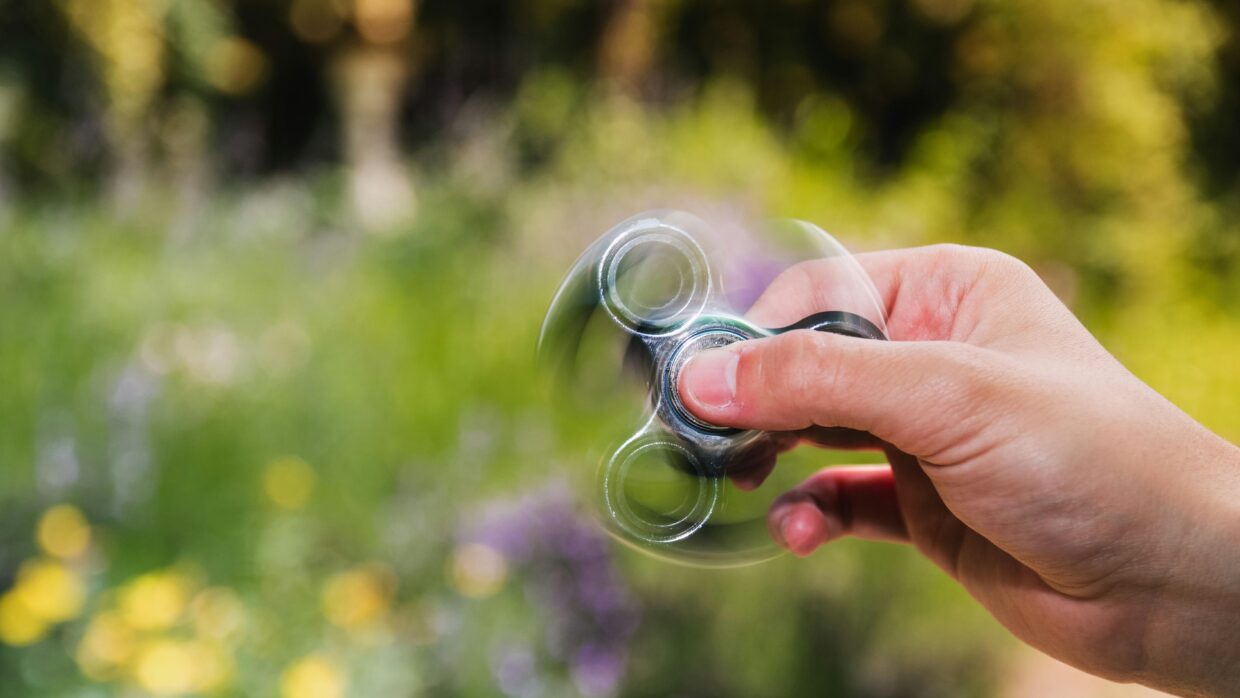 Main tenant un jouet anti stress fidget toy en plein air, manipulation sensorielle pour réduire le stress