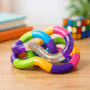 Tangle fidget coloré aux maillons courbés multicolores et pailletés posé sur un bureau — test et avis 2026